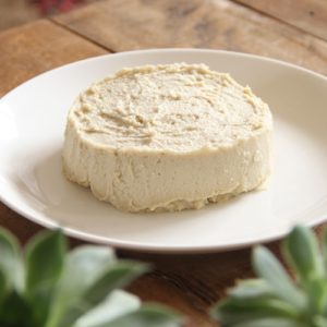 A round of homemade nut cheese on a plate