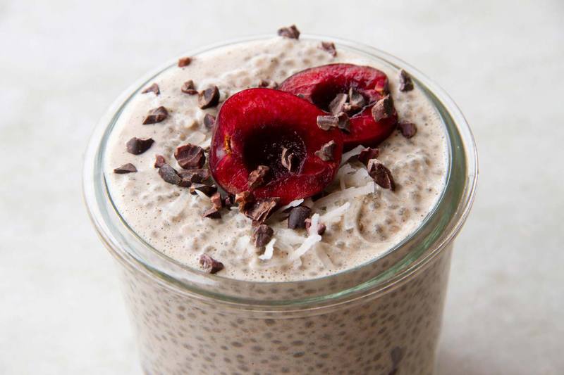 Close up of a jar filled with chia pudding, focusing on the fresh sliced cherries on top