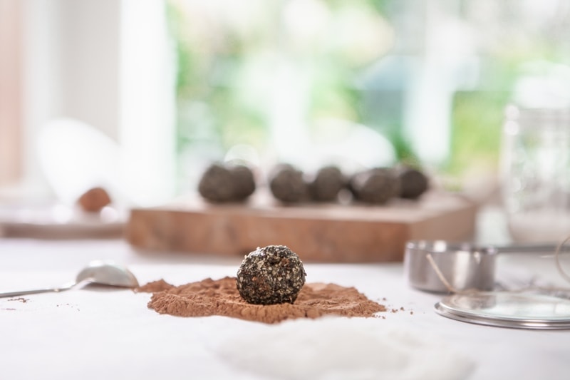 A freshly made bliss ball about to be rolled in cacao powder