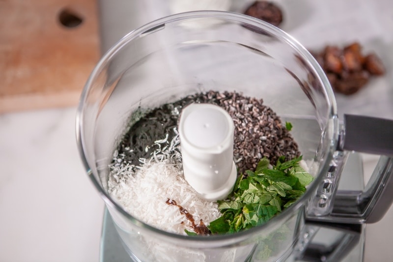 Food processor with all the ingredients for bliss balls inside ready to pulse