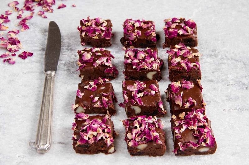 Side view of the recipe sliced into squares on a marble counter, showing the macadamia nuts and cherries inside