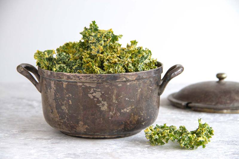 Rustic Indian-style pot heaped full of cheesy looking kale chips