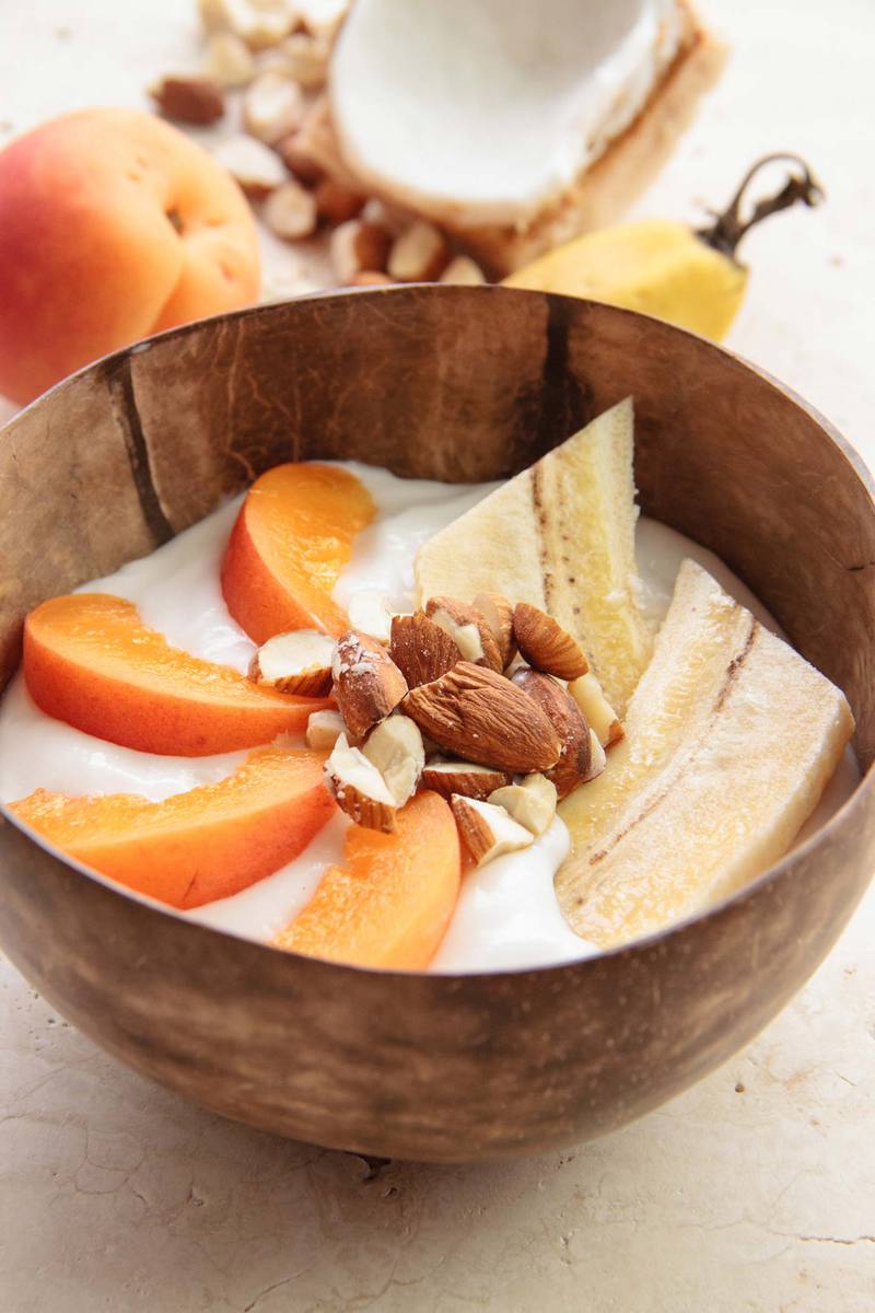 Bowl of homemade coconut yoghurt with fresh fruit on top