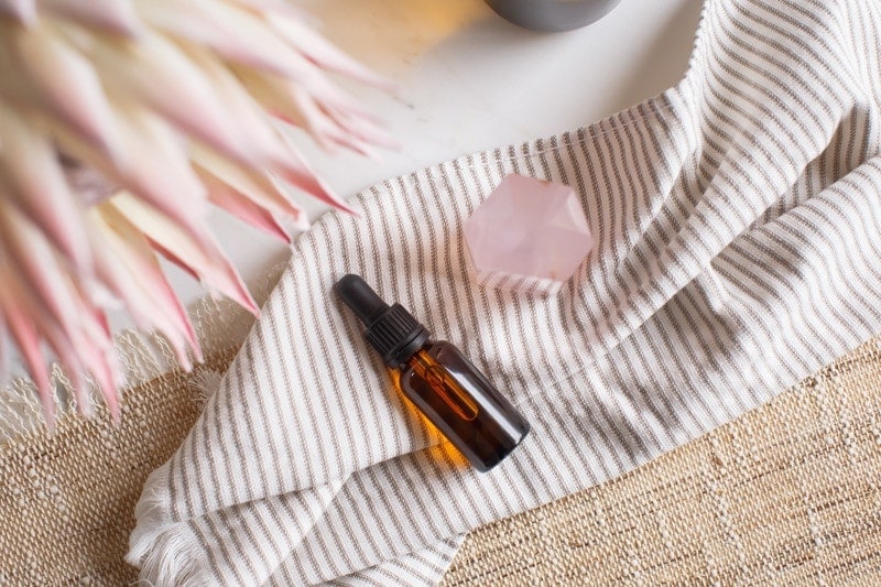 Small glass amber bottle filled with rose quartz elixir for love