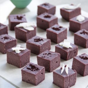 Cubes of purple coloured vegan fudge on a kitchen bench
