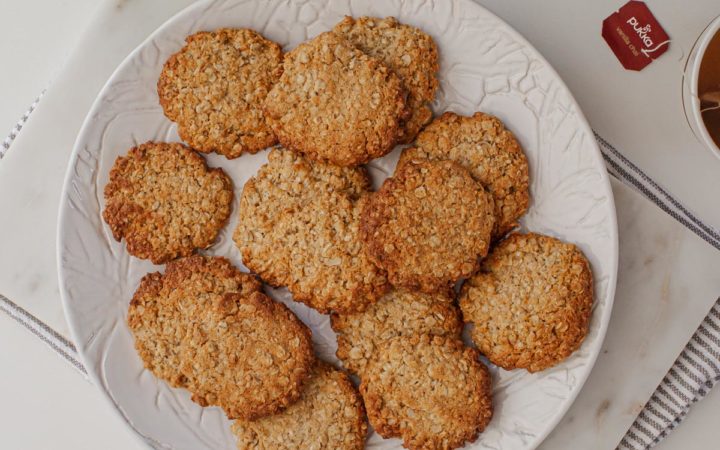 A plate filled with freshly baked ANZAC biscuits.