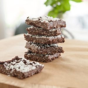 A stack of healthy homemade coconut rough slice on a chopping board