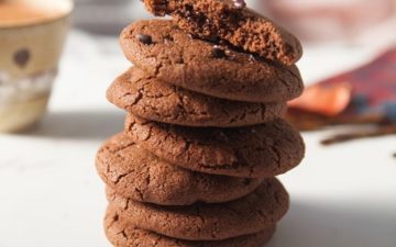 A towering stack of freshly baked cookies on the kitchen bench