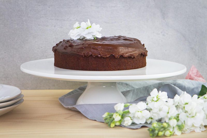 Vegan Chocolate Cake with Ganache presented beautifully on a cake stand