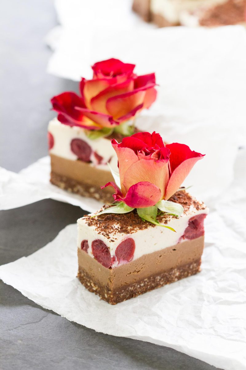Two Raw Black Forest Slices with roses on top, profile view of the layers
