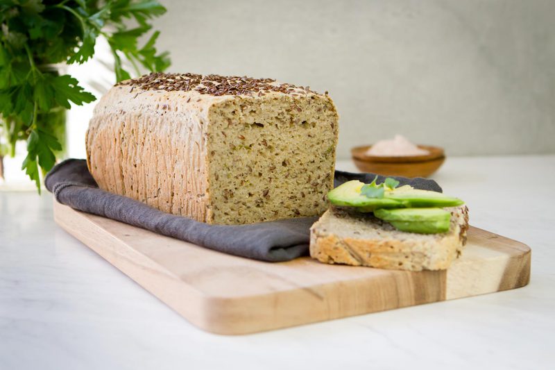 Freshly baked and sliced loaf of Millet Bread on a wooden board