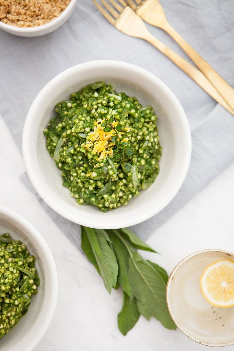 Overhead shot of a vegan Buckwheat Risotto on the dinner table with gold cutlery