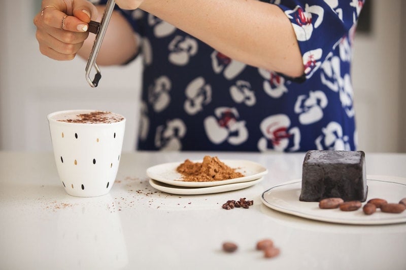 Benefits of Cacao: Lauren grating chocolate over a hot cacao