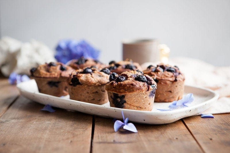 A tray of Gluten Free Blueberry Muffins made with teff flour on a rustic table