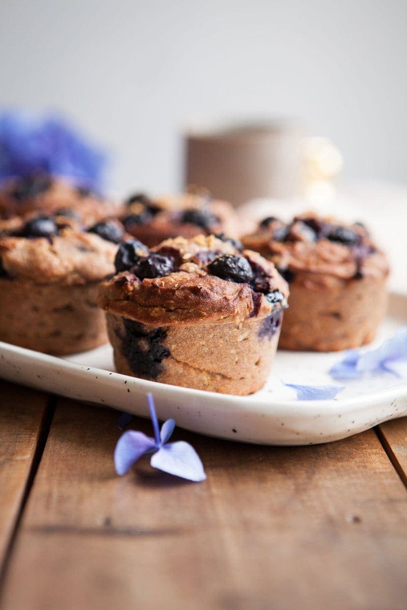 Close up of Gluten Free Blueberry Muffins showing blueberries and lemon zest pressed into the tops