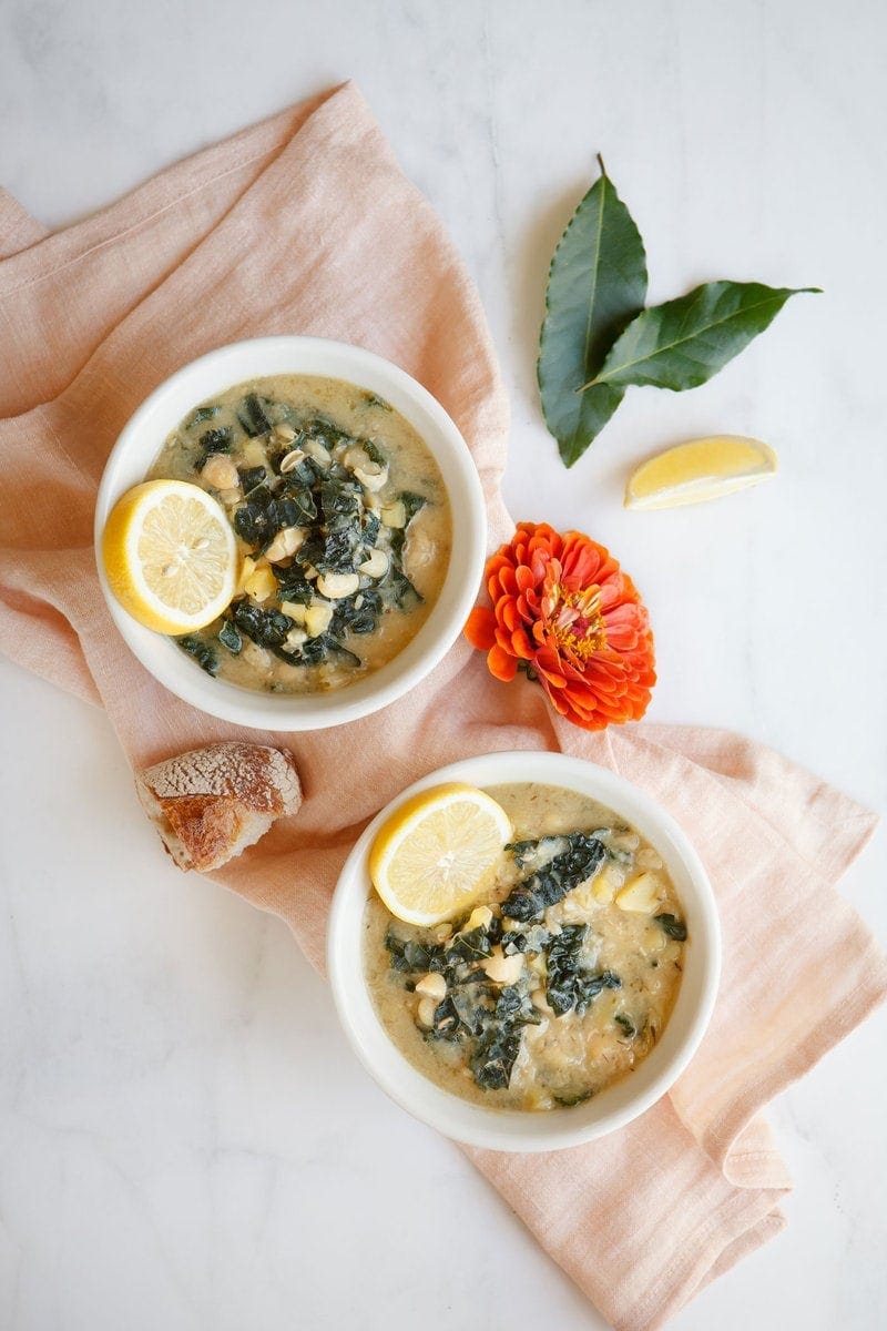 Overhead shot of two bowls of soup showing the wilted greens and white beans.