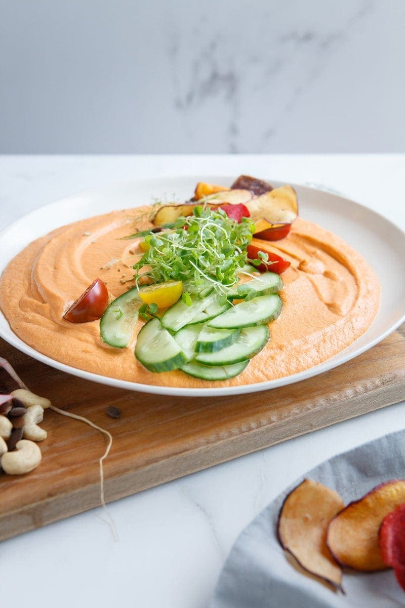 Chargrilled Capsicum Hummus on a plate on a serving board with chips