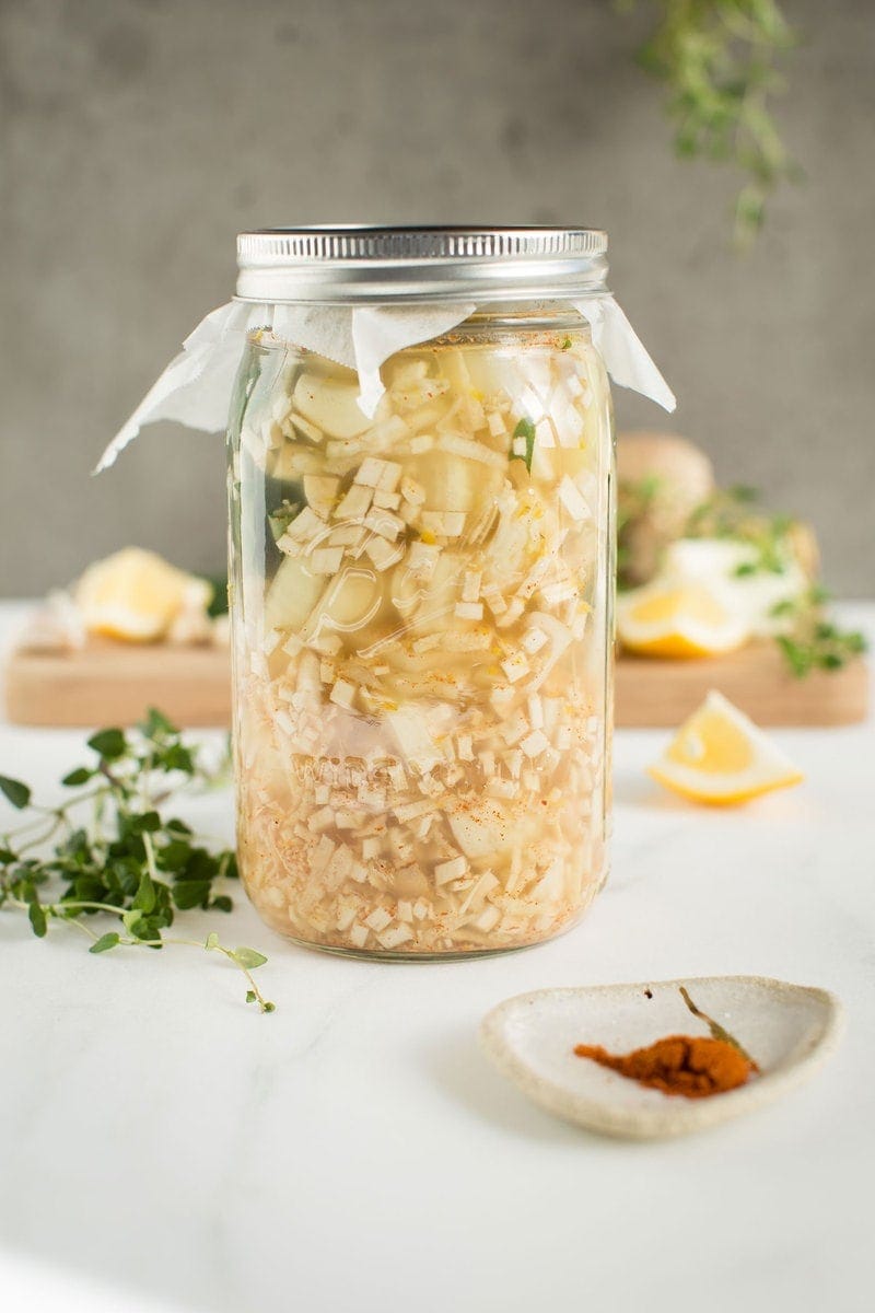 Homemade fire cider in a glass jar infusing 