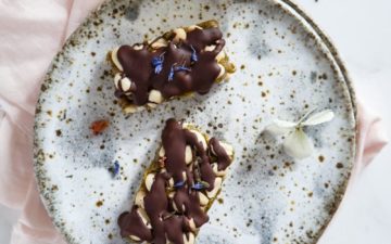 An indulgent raw pistachio Salted Caramel Slice – with peanuts and a drizzle of dark chocolate. #rawveganslice #saltedcaramelslice #pistachiorecipe #saltedcaramelsliceraw #saltedcaramelslicevegan #saltedcaramelslicepaleo #saltedcaramelslicerecipe #homemadesaltedcaramel #AscensionKitchen // Pin to your own inspiration board! //