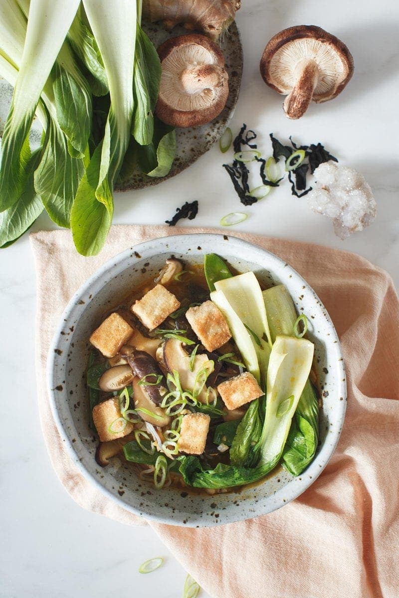 Close up of Shiitake Immuno-Soup in a bowl with shiitake mushrooms beside it