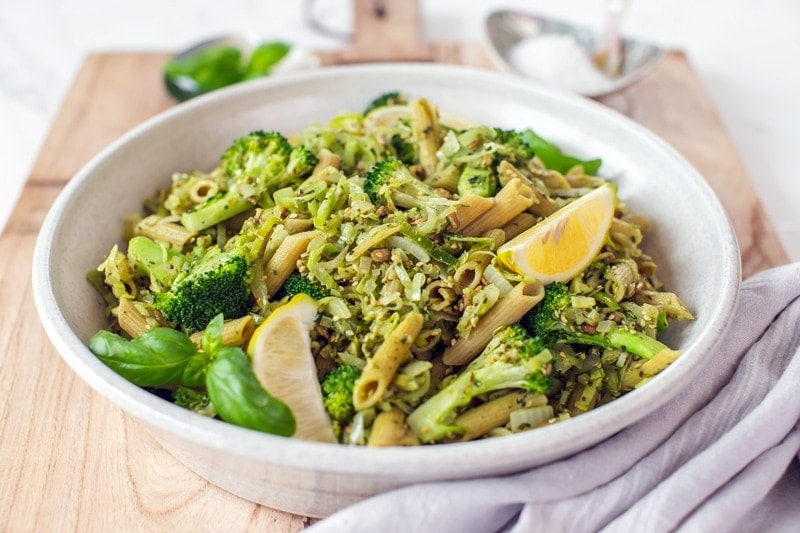A family sized bowl of broccoli pasta on a serving board