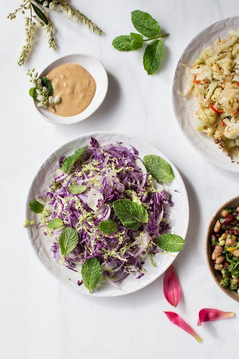 Dinner spread featuring healthy slaw with a side of creamy miso tahini dressing