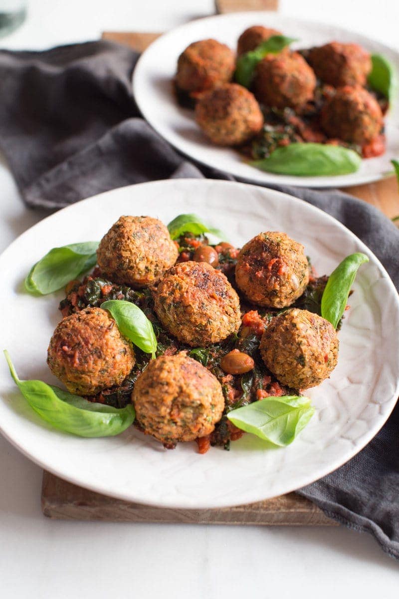 Close up of vegan lentil meatballs on a plate garnished with fresh basil ready to eat