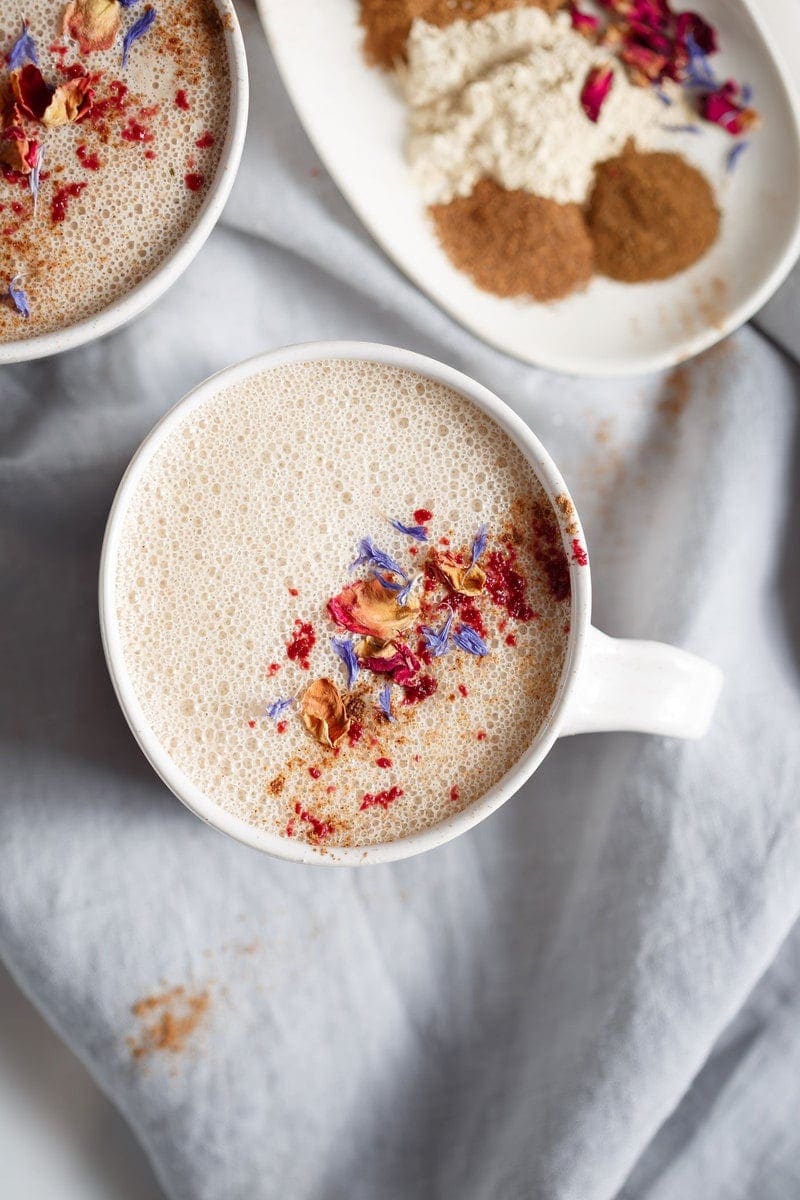 Close up of a mug of ashwagandha sleep tonic dusted with dried flower petals