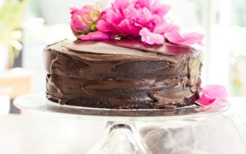 Frosted two layer chocolate beet cake on a cake stand