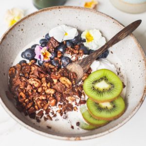 Close up of granola in bowl made with nuts, seeds and cacao and without grains