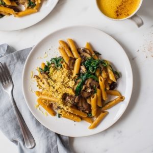 Creamy mushroom pasta on a plate with a blue napkin