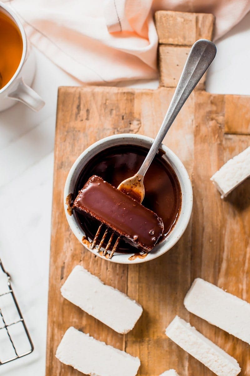 Close up of a bounty bar being coated in chocolate with a fork