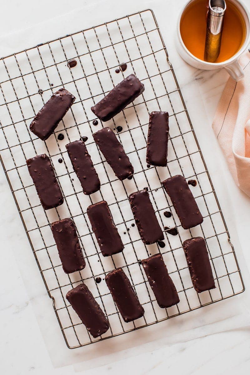 14 Bounty bars freshly coated in raw chocolate on a wire rack