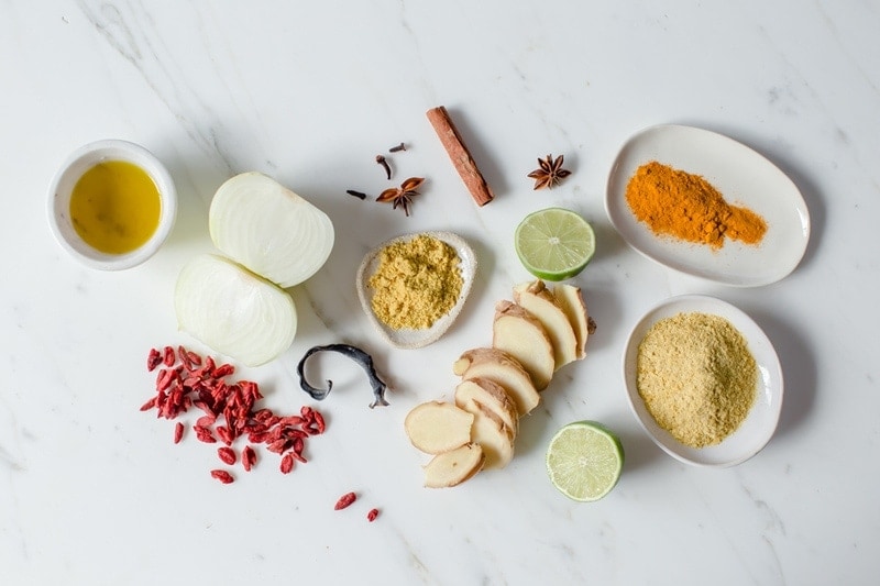 Ingredients used in a vegan broth to make Pho, in a lay over a white marble tile