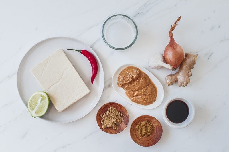 Ingredients for a vegan satay sauce laid out on the kitchen bench