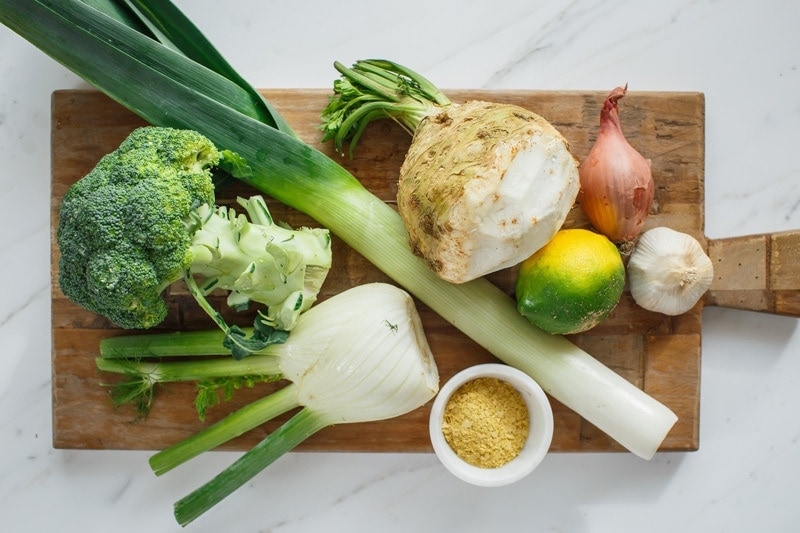Ingredients for celeriac soup laid out on a wooden chopping board