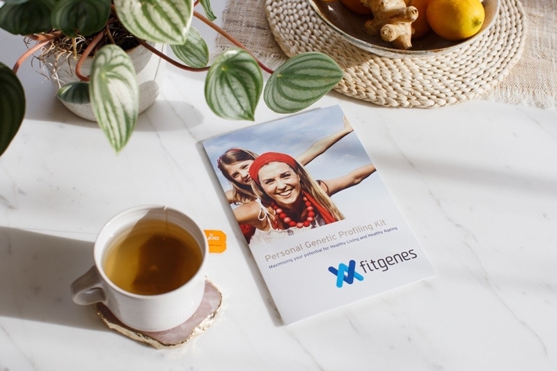 FitGenes genetic profiling kit on a coffee table with a cup of tea.