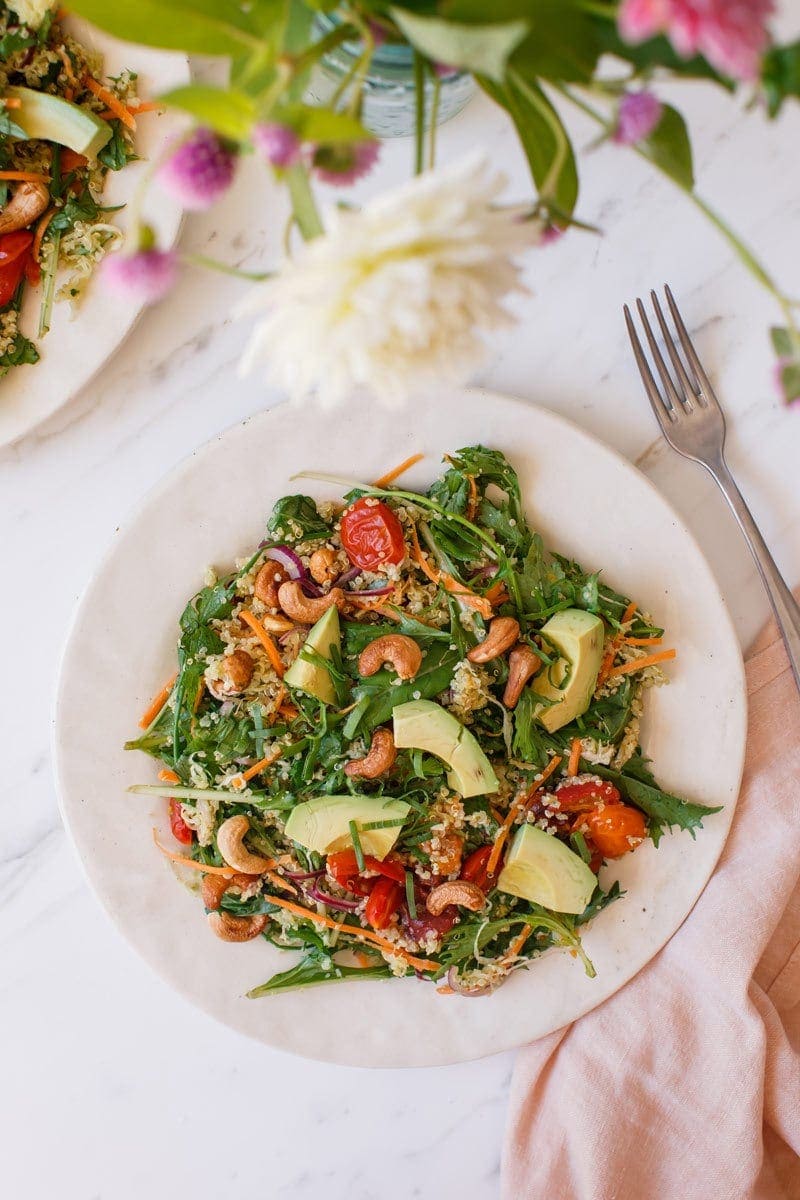 A colourful quinoa salad with avocado and green goddess dressing served on a plate