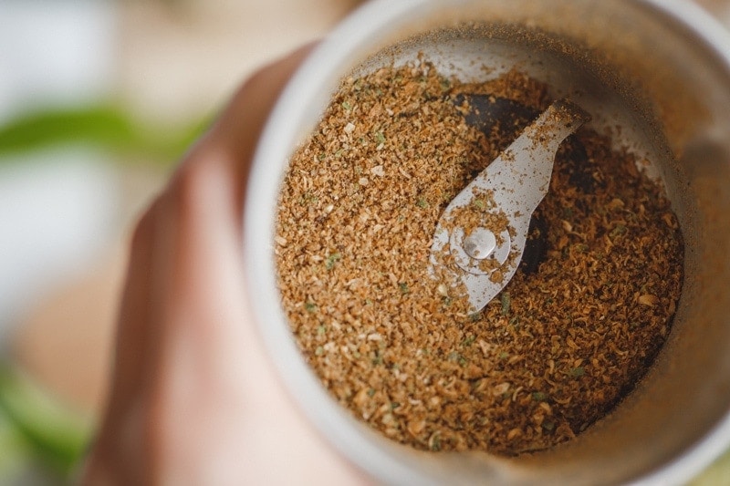 Spices for a green curry paste in a spice grinder