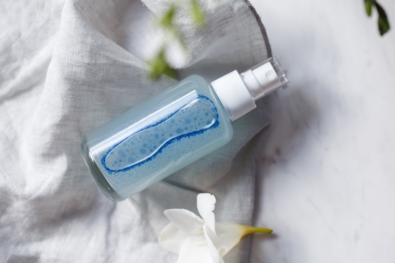 A bottle of homemade facial toner - a luminous blue colour