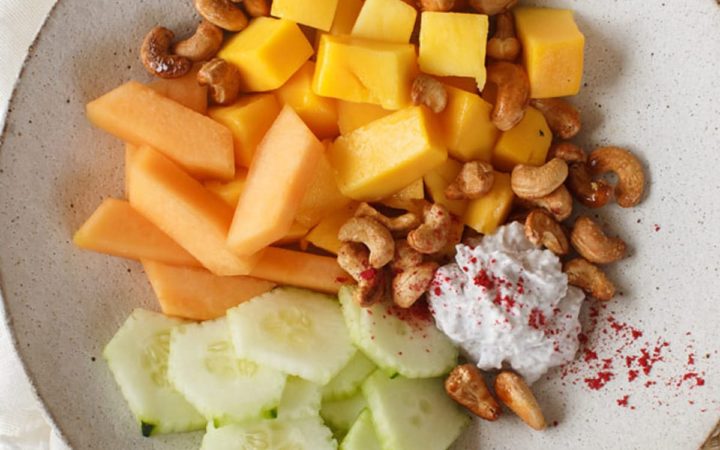 Tropical fruit platter topped with roasted cashews and dusted with freeze dried raspberry powder