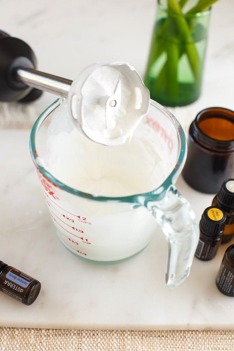 Close up of freshly whipped DIY face cream, in a pyrex jug with immersion blender