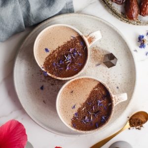 Two mugs of hot chocolate dusted with cacao