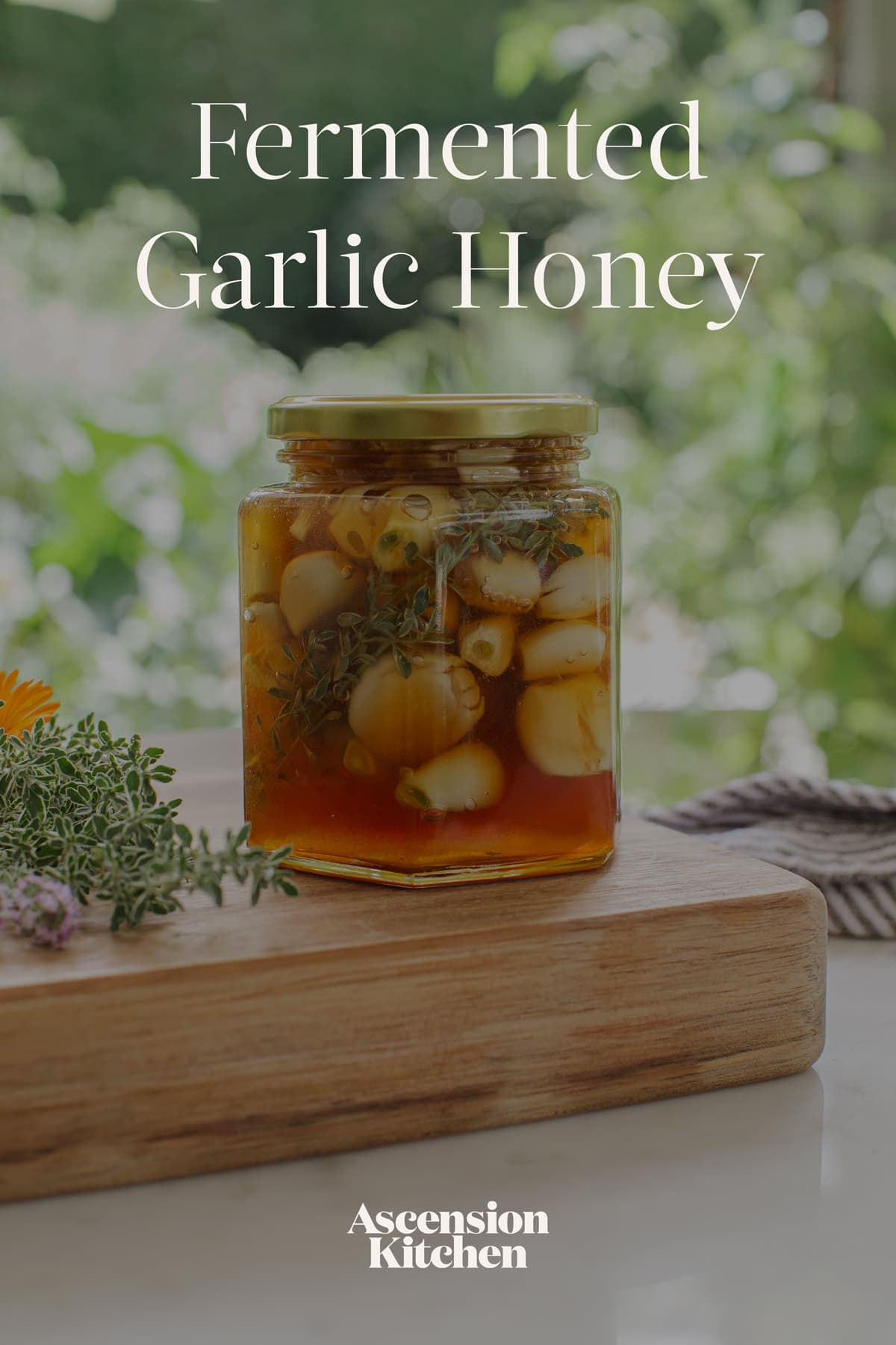 Fermented Garlic Honey in a jar on a plate with a napkin, sprig of thyme, and honey dipper