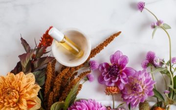 Home made perfume blend surrounded by flowers