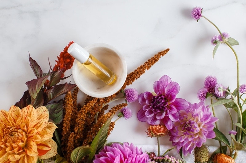 Home made perfume blend surrounded by flowers