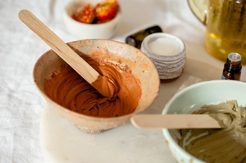 Close up of a red clay mask in a ceramic dish, for acne prone skin