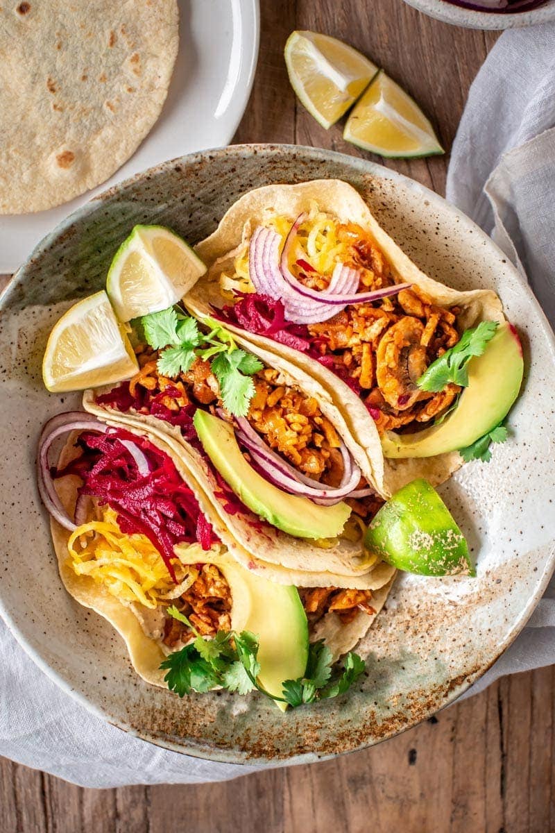 Close up of vegan tacos filled with tempeh mince and fresh vegetables