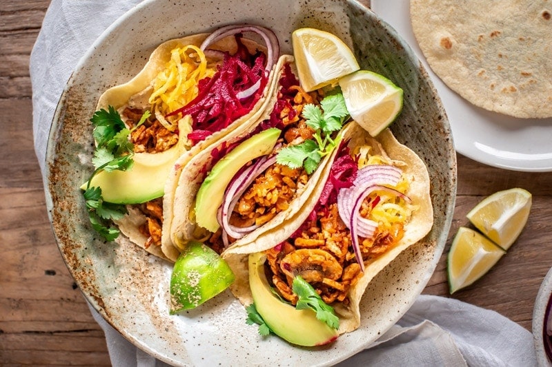 Three vegan tacos jam packed with colourful grated beets, herbs, avo and tempeh meat