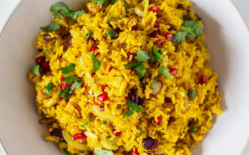 Vibrant saffron rice topped with fresh herbs and pomegranate arils.